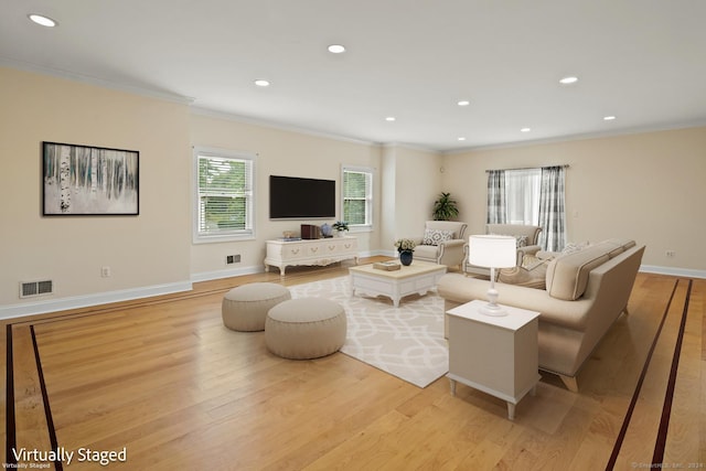 living room with ornamental molding and light hardwood / wood-style flooring