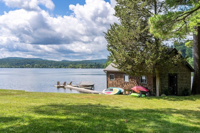 dock area with a yard and a water and mountain view