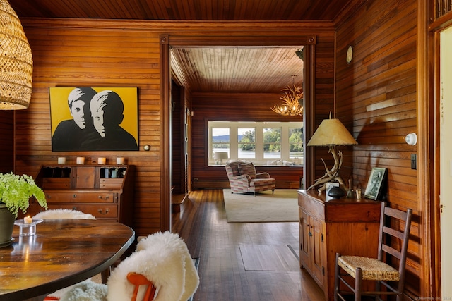 interior space featuring wooden walls, dark hardwood / wood-style flooring, wooden ceiling, and a notable chandelier