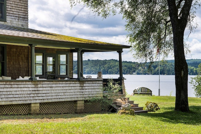 exterior space featuring a lawn and a water view