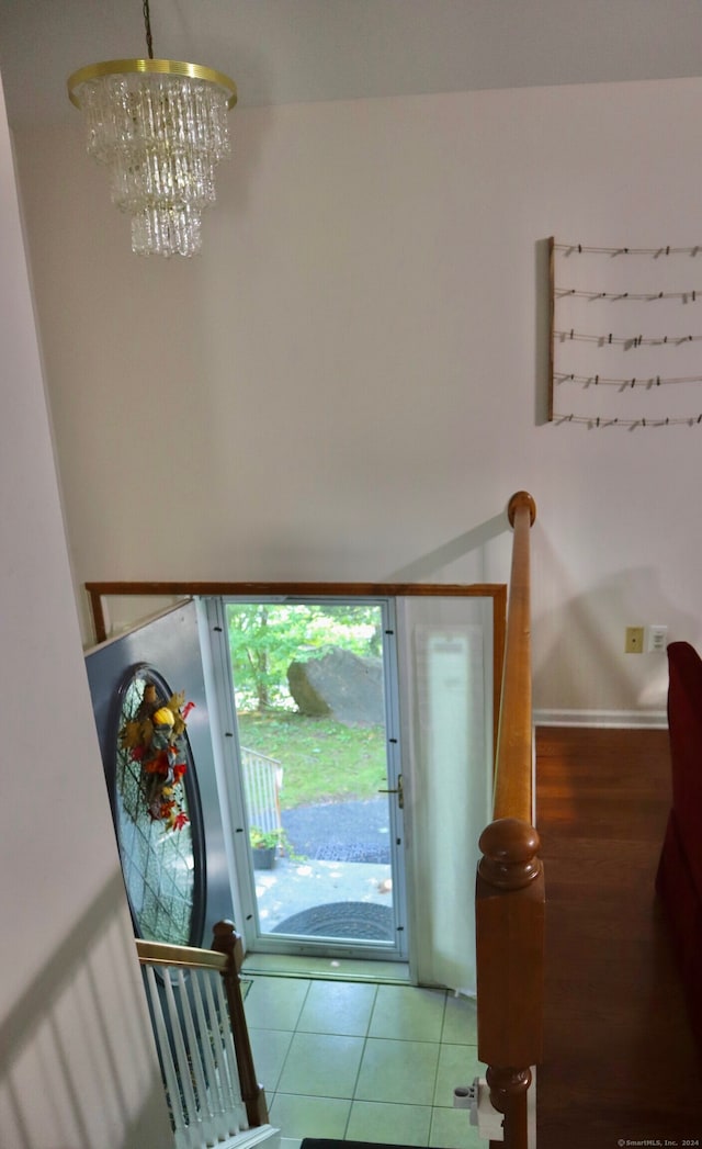 tiled foyer featuring an inviting chandelier