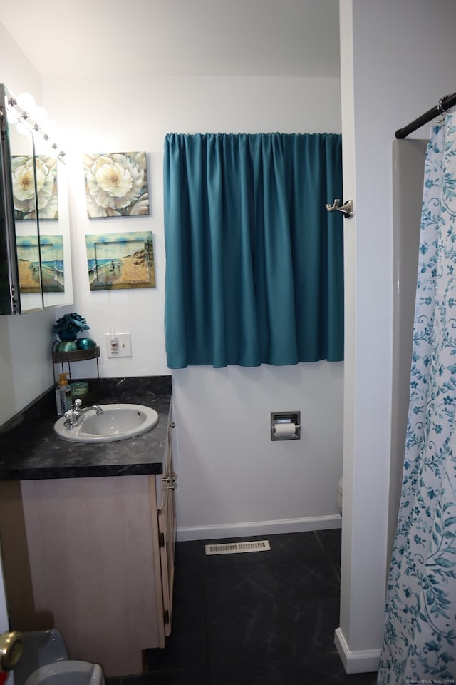 bathroom with vanity, tile patterned flooring, and toilet