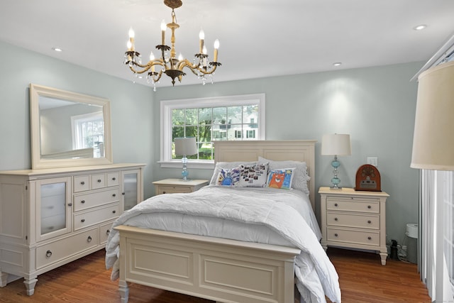 bedroom with a notable chandelier and dark hardwood / wood-style flooring