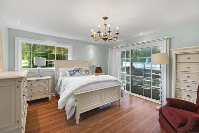 bedroom featuring hardwood / wood-style flooring, access to outside, and a chandelier