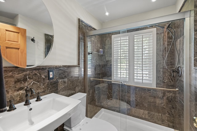 bathroom with sink, tile walls, an enclosed shower, and toilet