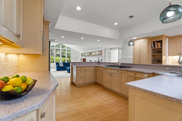 kitchen with sink, hanging light fixtures, light brown cabinets, kitchen peninsula, and light wood-type flooring