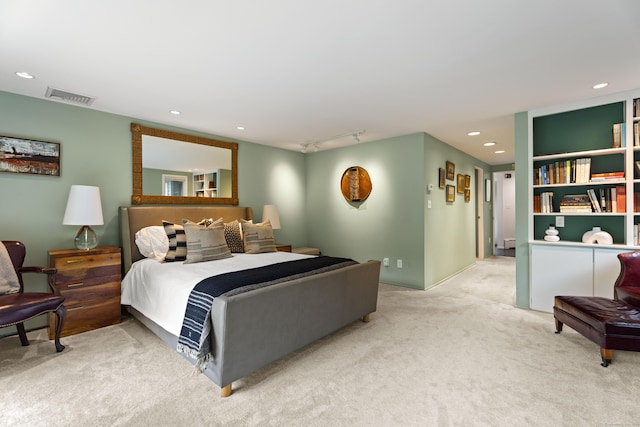 carpeted bedroom featuring rail lighting