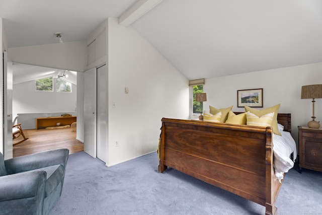 carpeted bedroom with lofted ceiling with beams and a closet