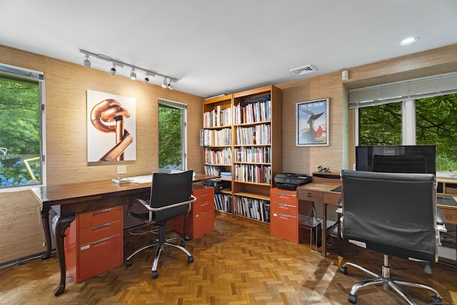 home office with parquet floors and a healthy amount of sunlight