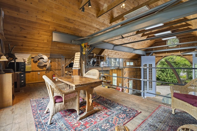 dining space with high vaulted ceiling, wooden ceiling, wooden walls, beamed ceiling, and light hardwood / wood-style floors