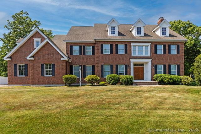 colonial inspired home featuring a front lawn