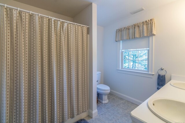 bathroom with tile patterned floors, curtained shower, vanity, and toilet