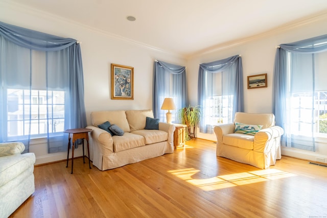 living area with light wood-type flooring and crown molding