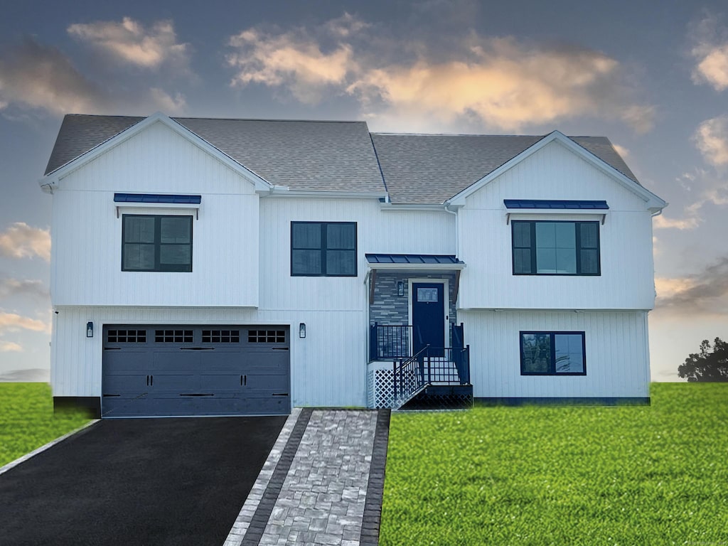 view of front of property with a yard and a garage