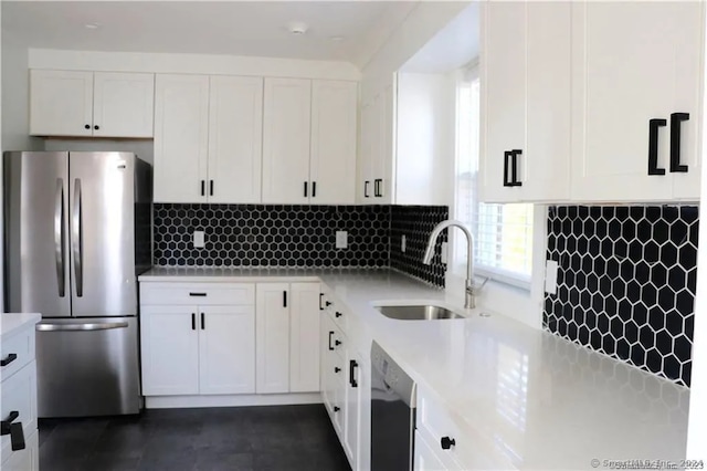 kitchen with backsplash, sink, white cabinets, and appliances with stainless steel finishes