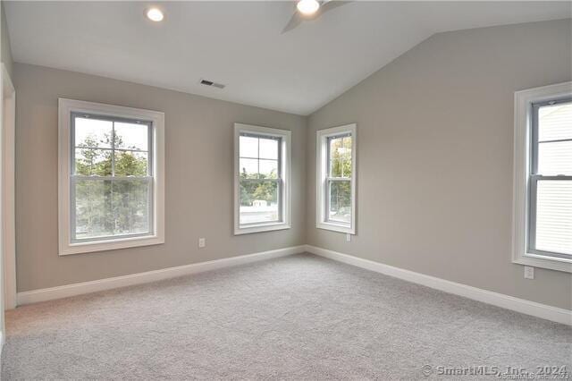 unfurnished room with carpet flooring, baseboards, lofted ceiling, and visible vents