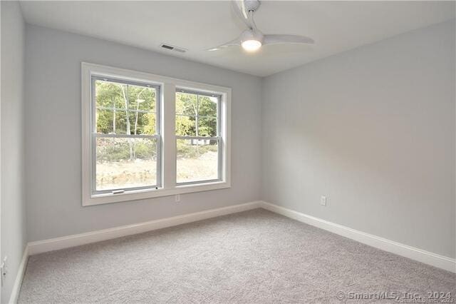 spare room with baseboards, carpet, and a ceiling fan