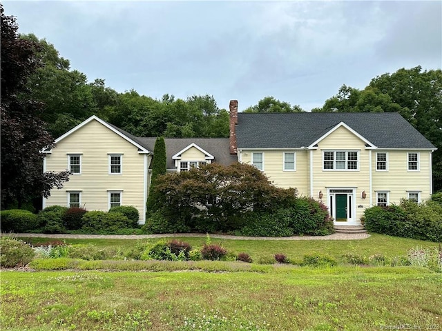 view of front of house featuring a chimney and a front lawn