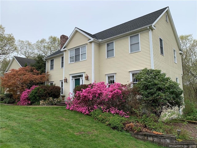 view of front of property featuring a front yard and a chimney