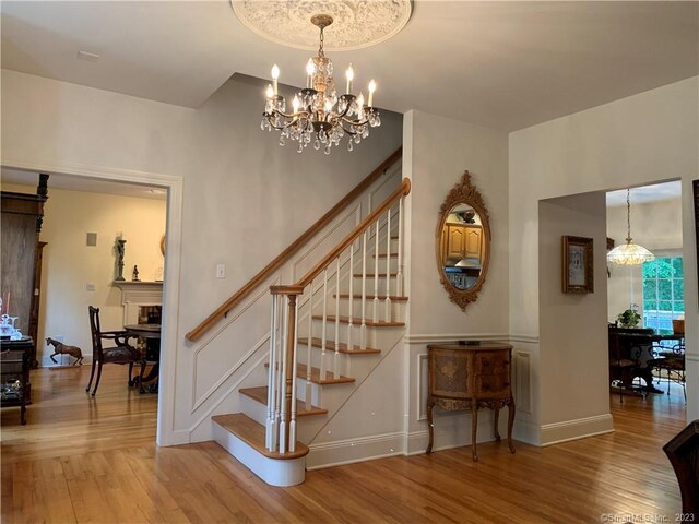 stairs with a notable chandelier and hardwood / wood-style flooring