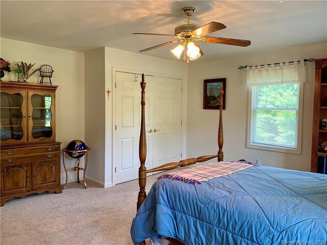 bedroom with a closet, ceiling fan, and carpet floors