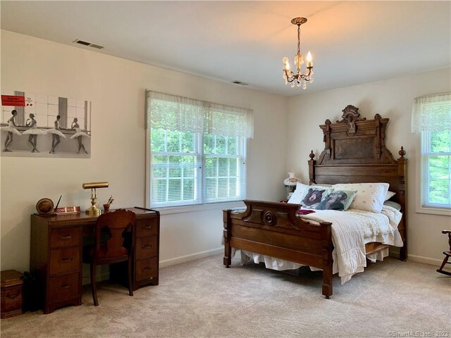 bedroom with a chandelier and light colored carpet