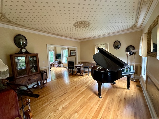 miscellaneous room featuring ornamental molding and light hardwood / wood-style flooring