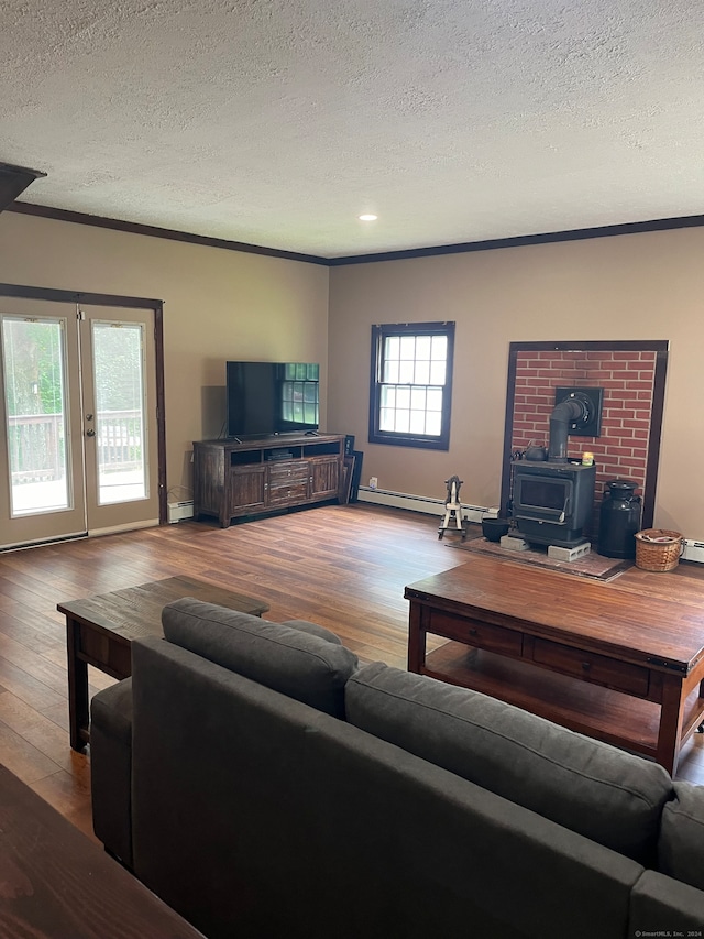 living room with light hardwood / wood-style flooring, a wood stove, a textured ceiling, and crown molding