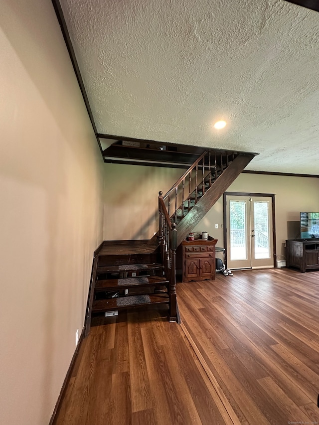 stairway featuring a textured ceiling and hardwood / wood-style flooring