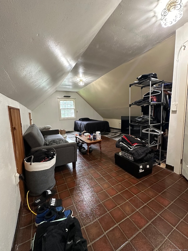 bonus room featuring dark tile patterned flooring, a textured ceiling, and lofted ceiling