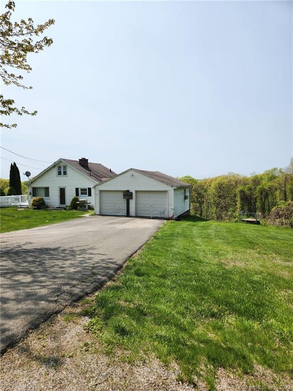 single story home featuring a garage and a front lawn