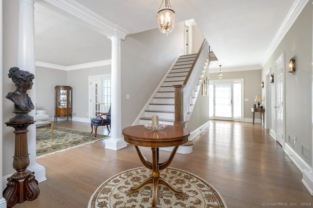 entrance foyer with hardwood / wood-style flooring, ornamental molding, and decorative columns