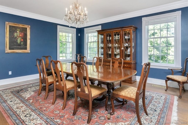 dining area with crown molding, an inviting chandelier, and a wealth of natural light