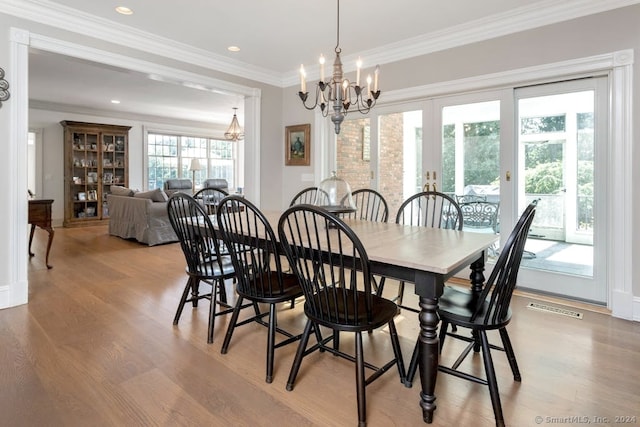 dining room with french doors, ornamental molding, a notable chandelier, and light hardwood / wood-style flooring