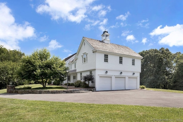 view of property exterior with a garage and a yard