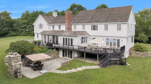 rear view of house featuring a patio, a yard, a deck, and french doors