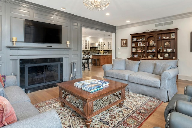 living room with ornamental molding and light wood-type flooring