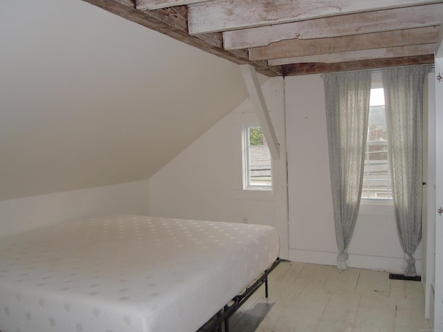 unfurnished bedroom featuring vaulted ceiling and multiple windows