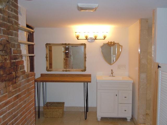 bathroom with brick wall, tile patterned floors, and vanity