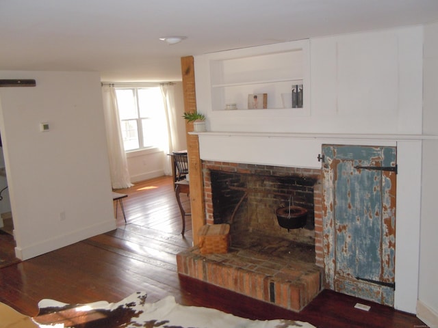 living room featuring hardwood / wood-style flooring and a brick fireplace