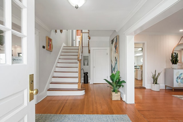 foyer entrance with wood-type flooring and ornamental molding