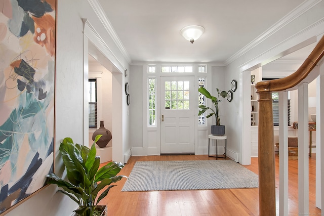 foyer featuring ornamental molding, a baseboard radiator, and hardwood / wood-style floors