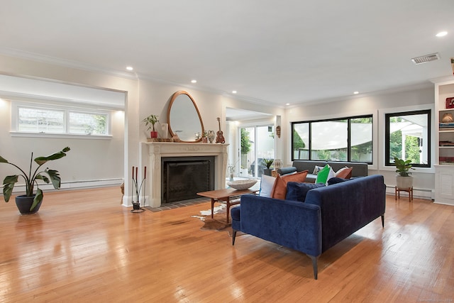 living room featuring light hardwood / wood-style floors, baseboard heating, and plenty of natural light