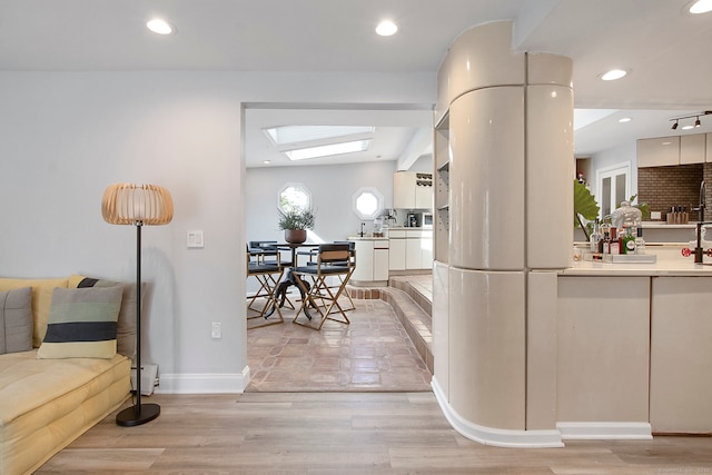 interior space with a skylight and light wood-type flooring