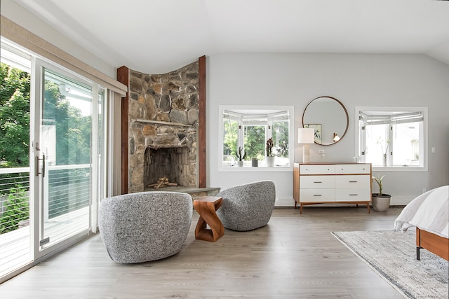 bedroom featuring light hardwood / wood-style flooring, multiple windows, and a fireplace