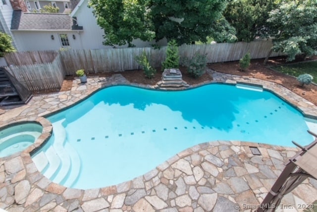 view of pool with an in ground hot tub