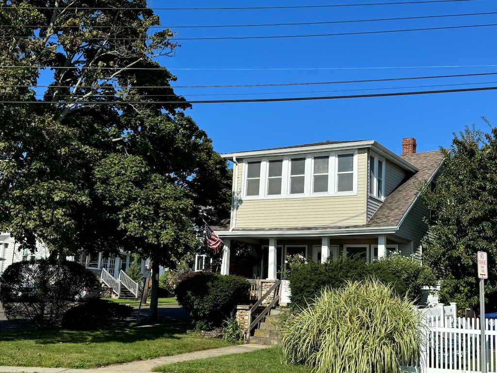 view of front of property with a front yard and covered porch