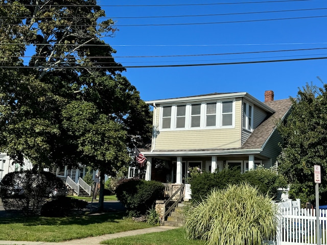 view of front of property with a front yard and covered porch