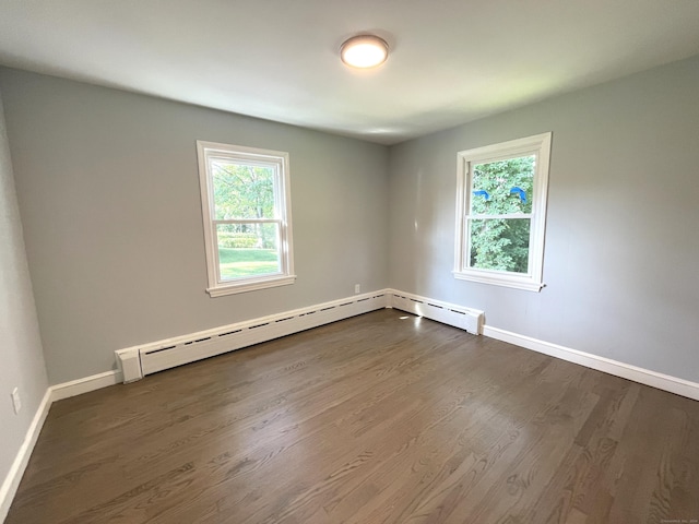 spare room featuring dark hardwood / wood-style flooring and a baseboard radiator