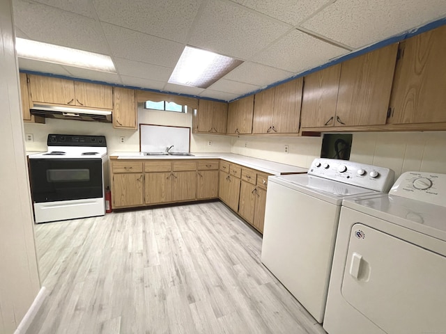 washroom with separate washer and dryer, sink, and light wood-type flooring